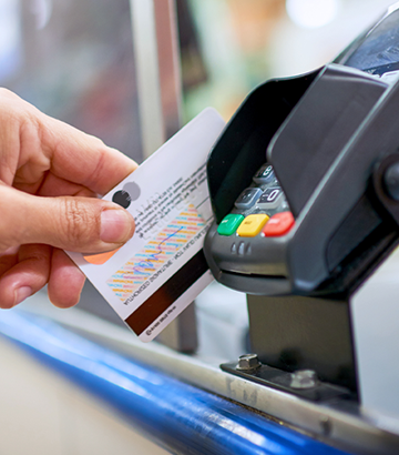 Close-up of hand swiping credit card through reader