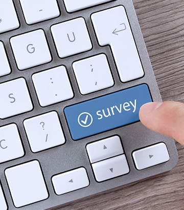 Finger about to push a button on keyboard that says "survey"
